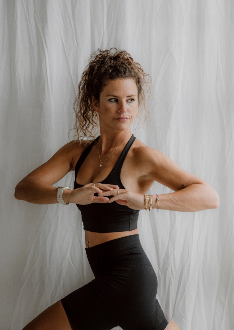 Eine Frau in Sportkleidung posiert vor einem weißen Hintergrund, Goldenbody Shop Ch.