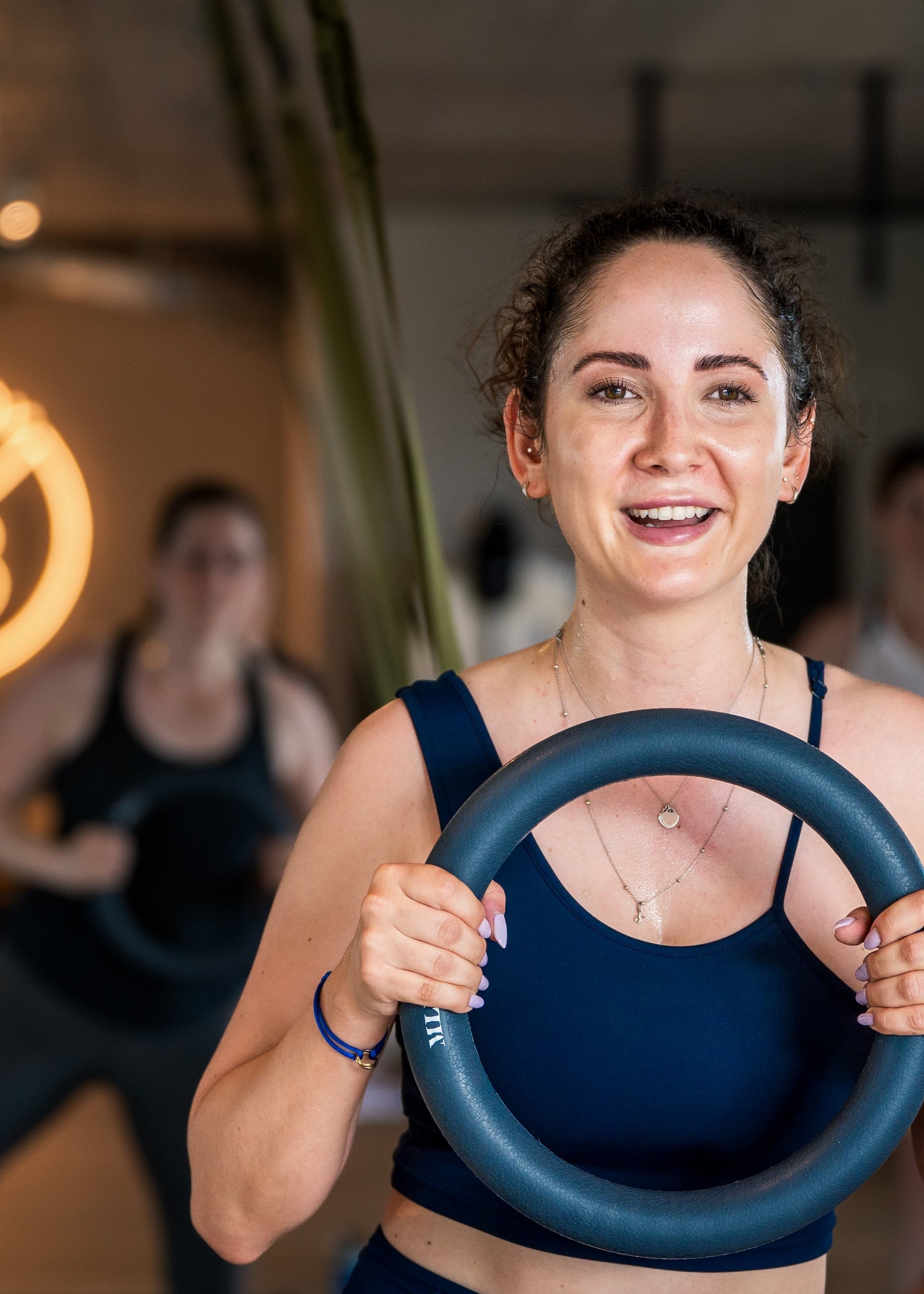 Frau trainiert mit Fitnessring im Studio von Goldenbody Shop Ch, lächelnd und motiviert.