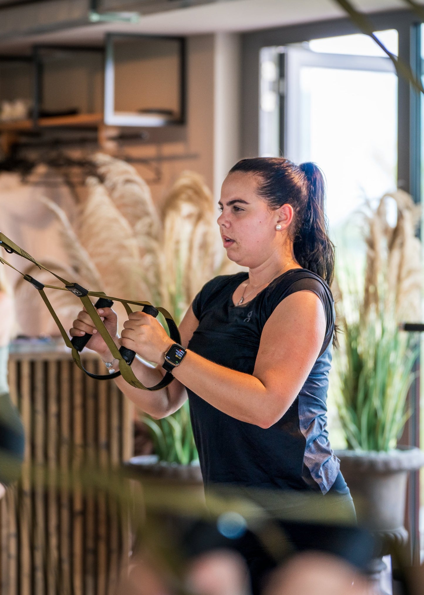 Eine Frau trainiert mit Fitnessbändern im Studio von Goldenbody Shop Ch.