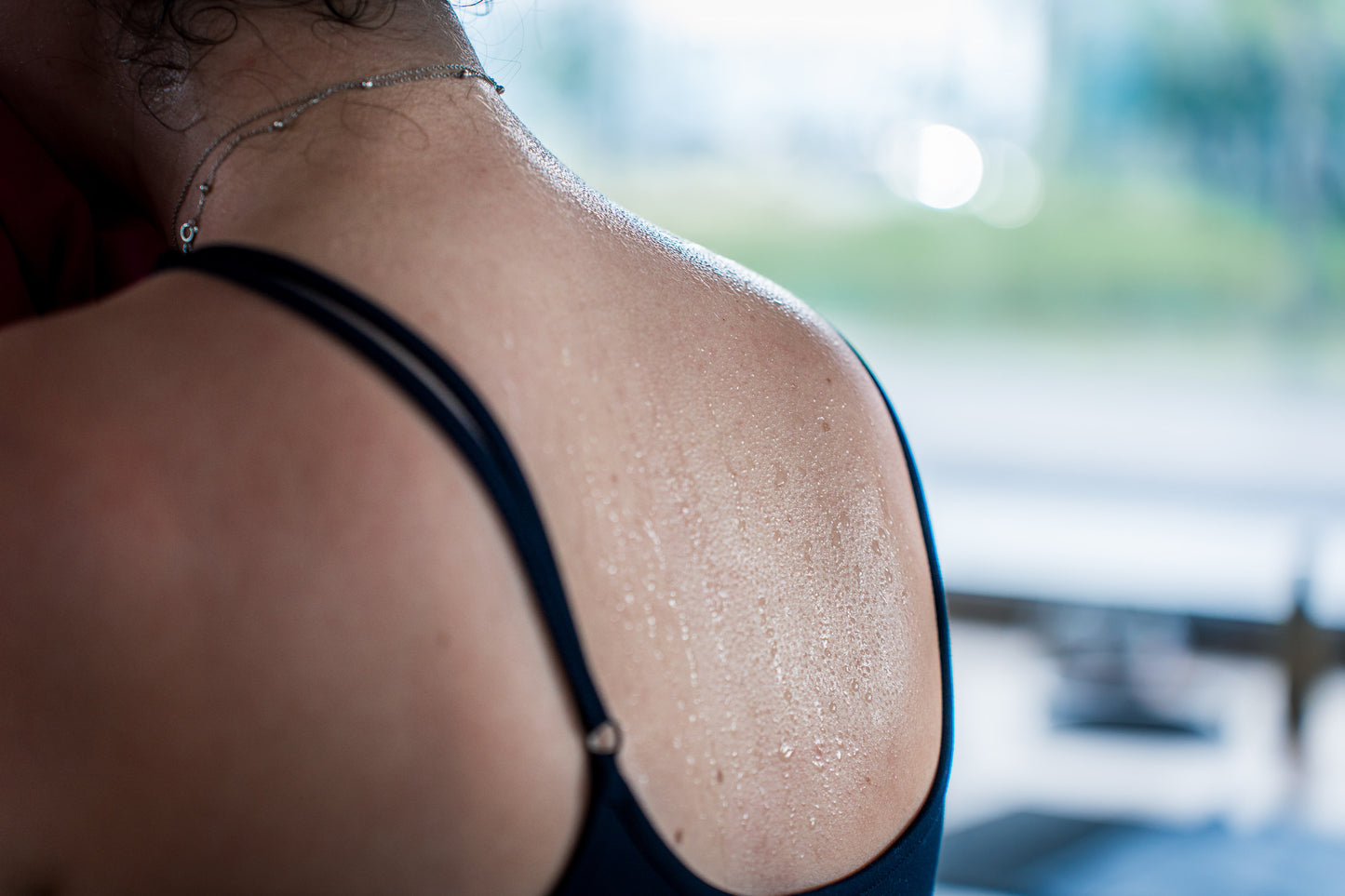 Eine verschwitzte Schulter in Sportkleidung, aufgenommen im Fitnessstudio von Goldenbody Shop Ch.