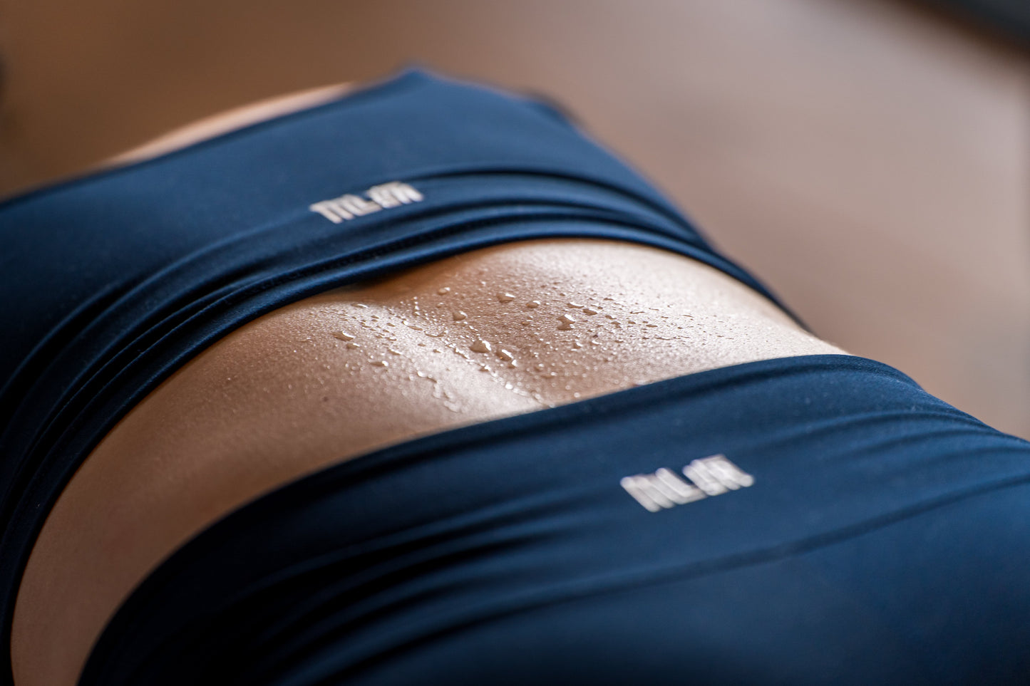 Nahaufnahme eines verschwitzten Bauches in Sportkleidung von Goldenbody Shop Ch.