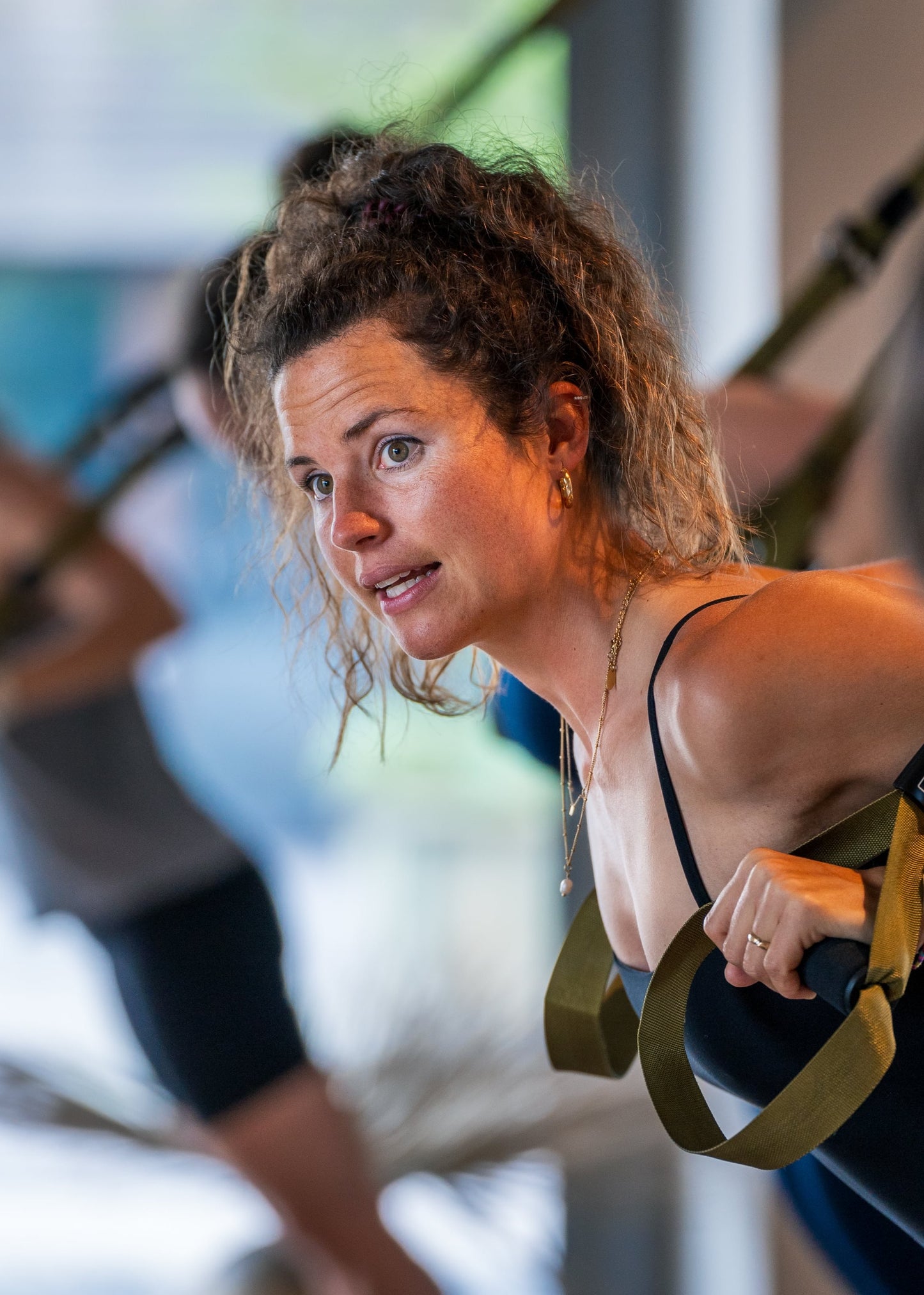 Eine Frau trainiert mit Fitnessbändern im Studio von Goldenbody Shop Ch.