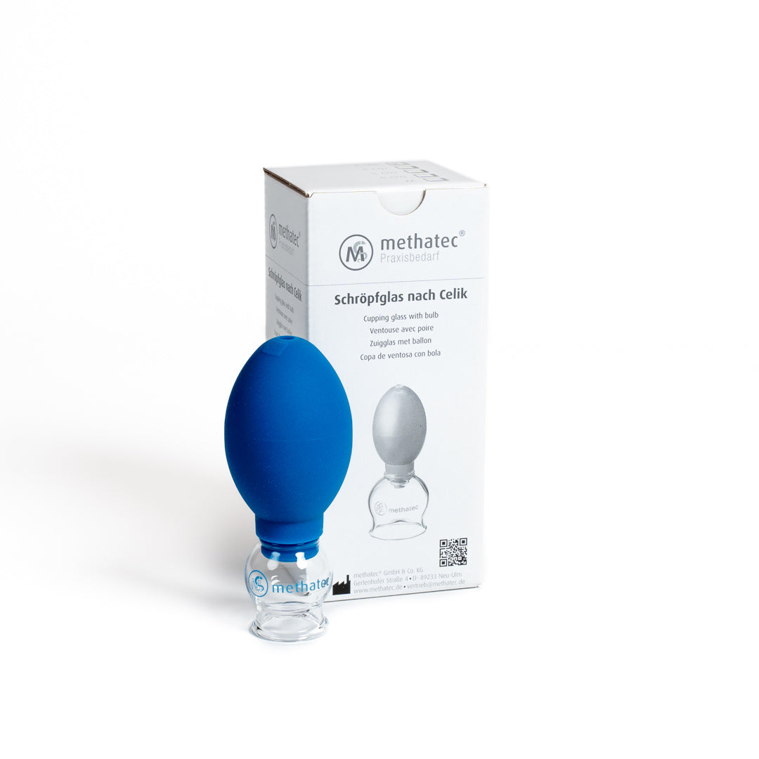 Ein blaues Schröpfglas von Goldenbody Shop Ch vor einer Verpackung.