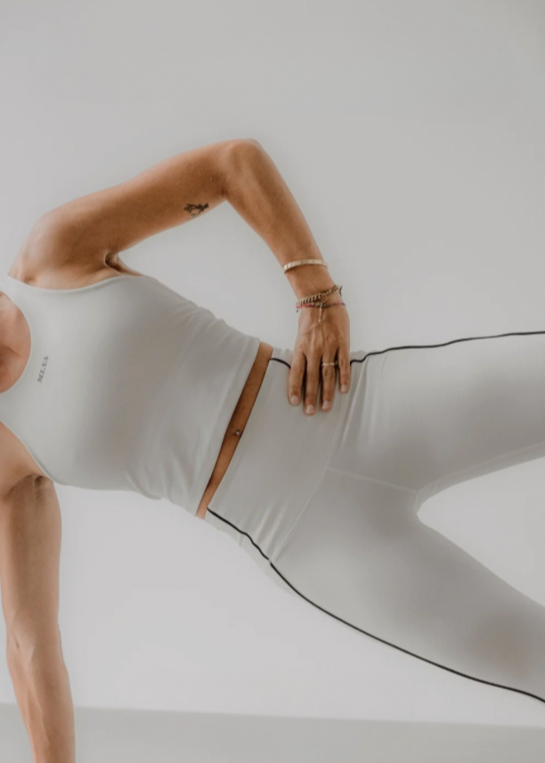 Eine Person in weißer Sportkleidung macht eine Plank-Übung, Goldenbody Shop Ch.