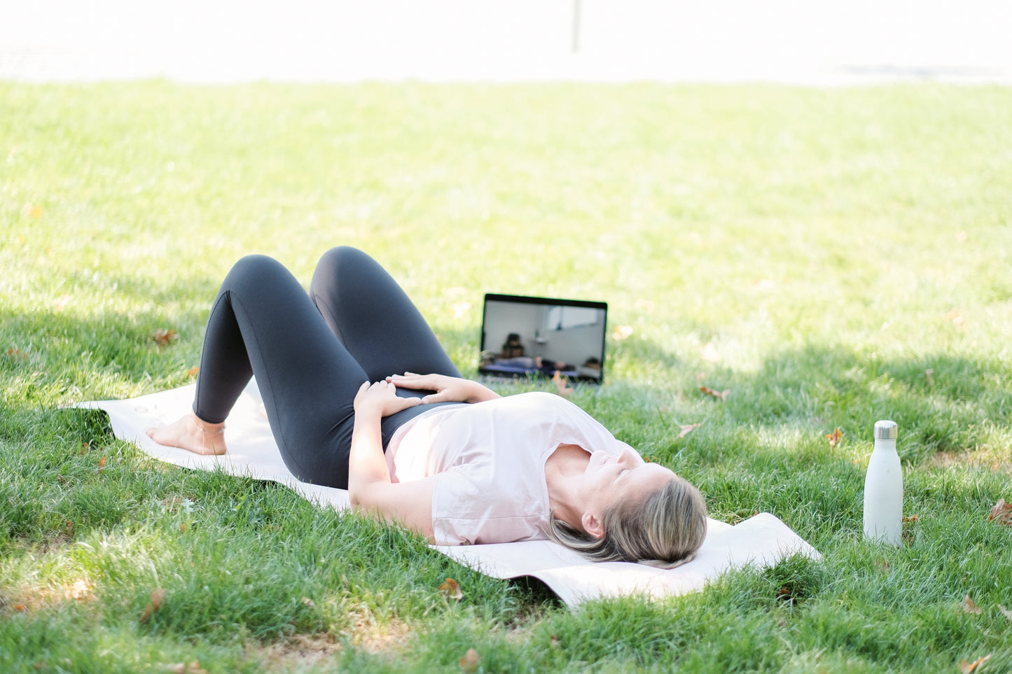 Eine Frau macht Entspannungsübungen im Park mit Goldenbody Shop Ch Onlinekurs.