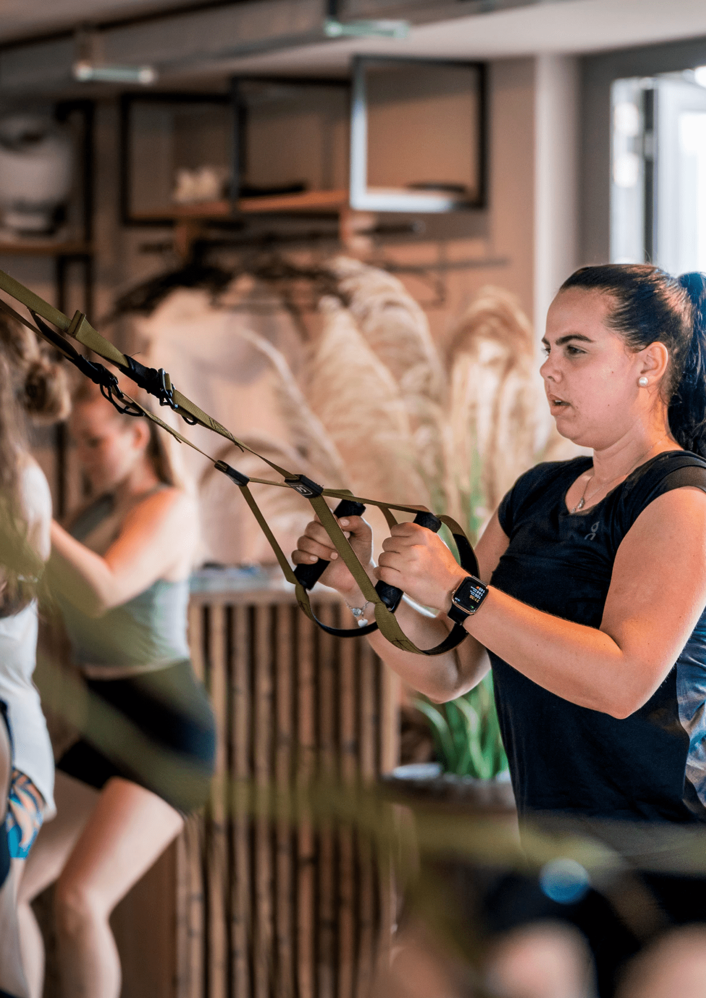Frau trainiert mit TRX-Bändern im Fitnessstudio von Goldenbody Shop Ch.