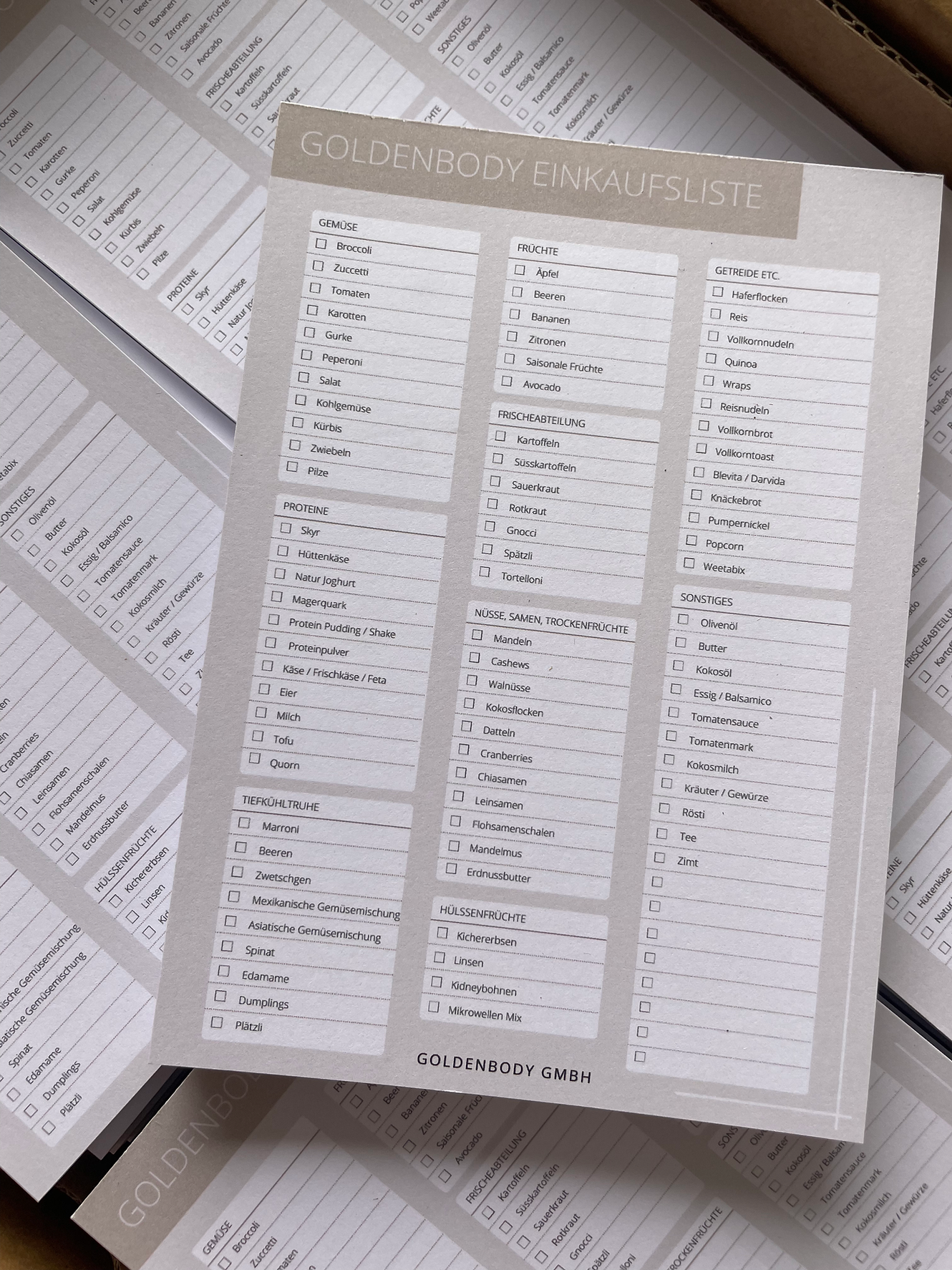 Eine detaillierte Einkaufsliste von Goldenbody Shop Ch auf einem Stapel Papier.