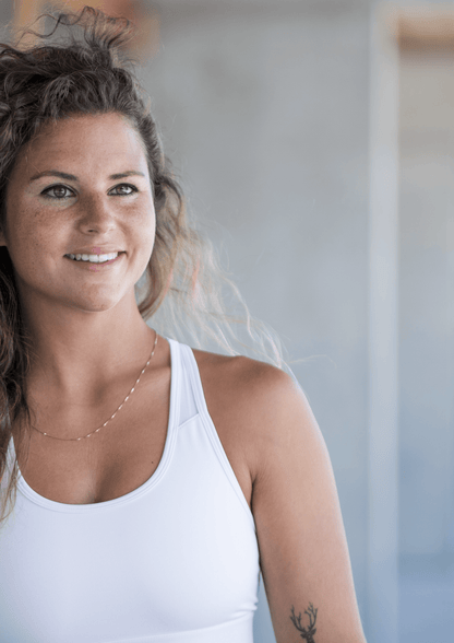 Eine lächelnde Frau in Sportkleidung, ideal für Goldenbody Shop Ch Fitnessprodukte.